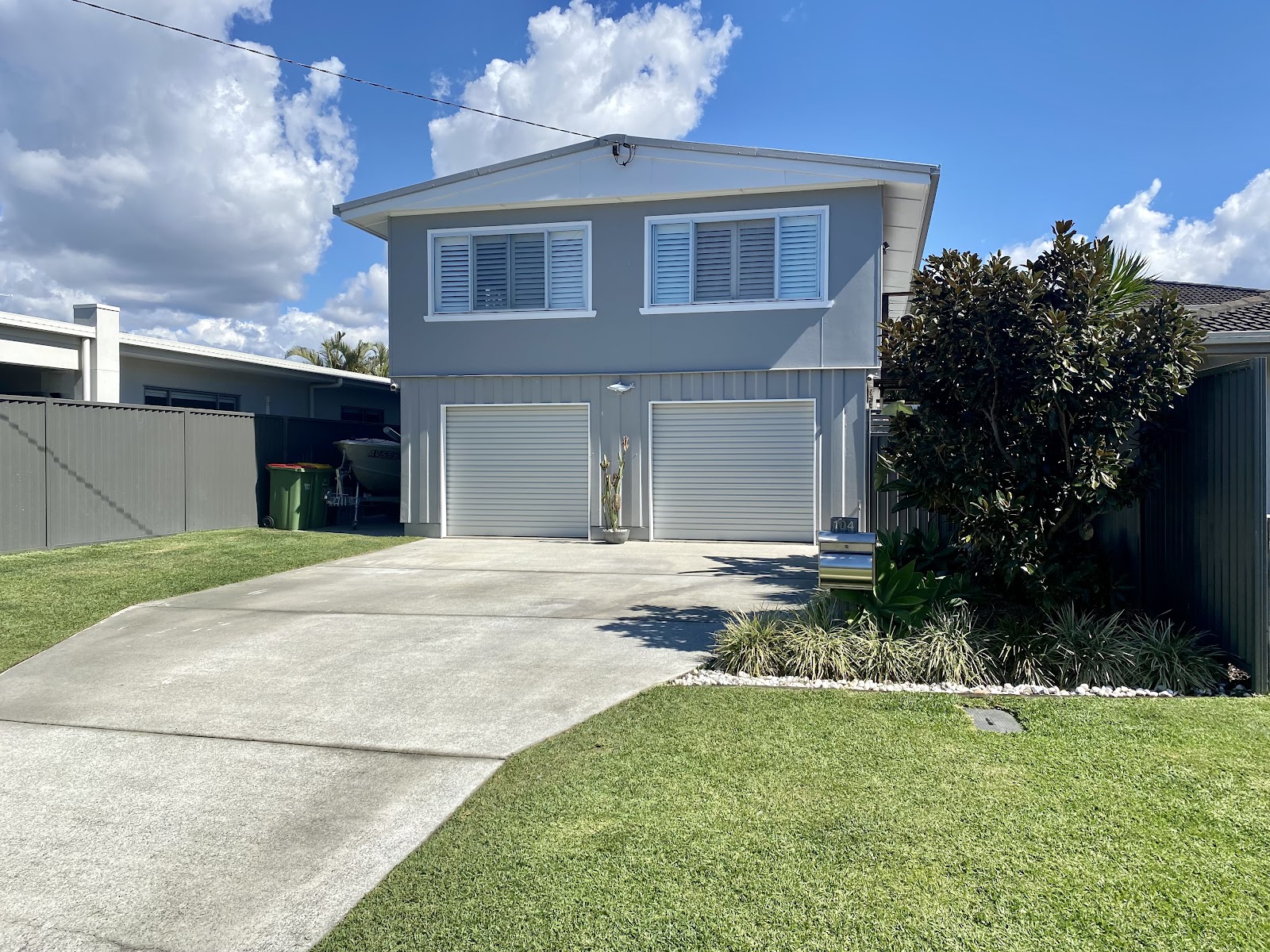 Two-storey home painted grey with white trim and a double garage